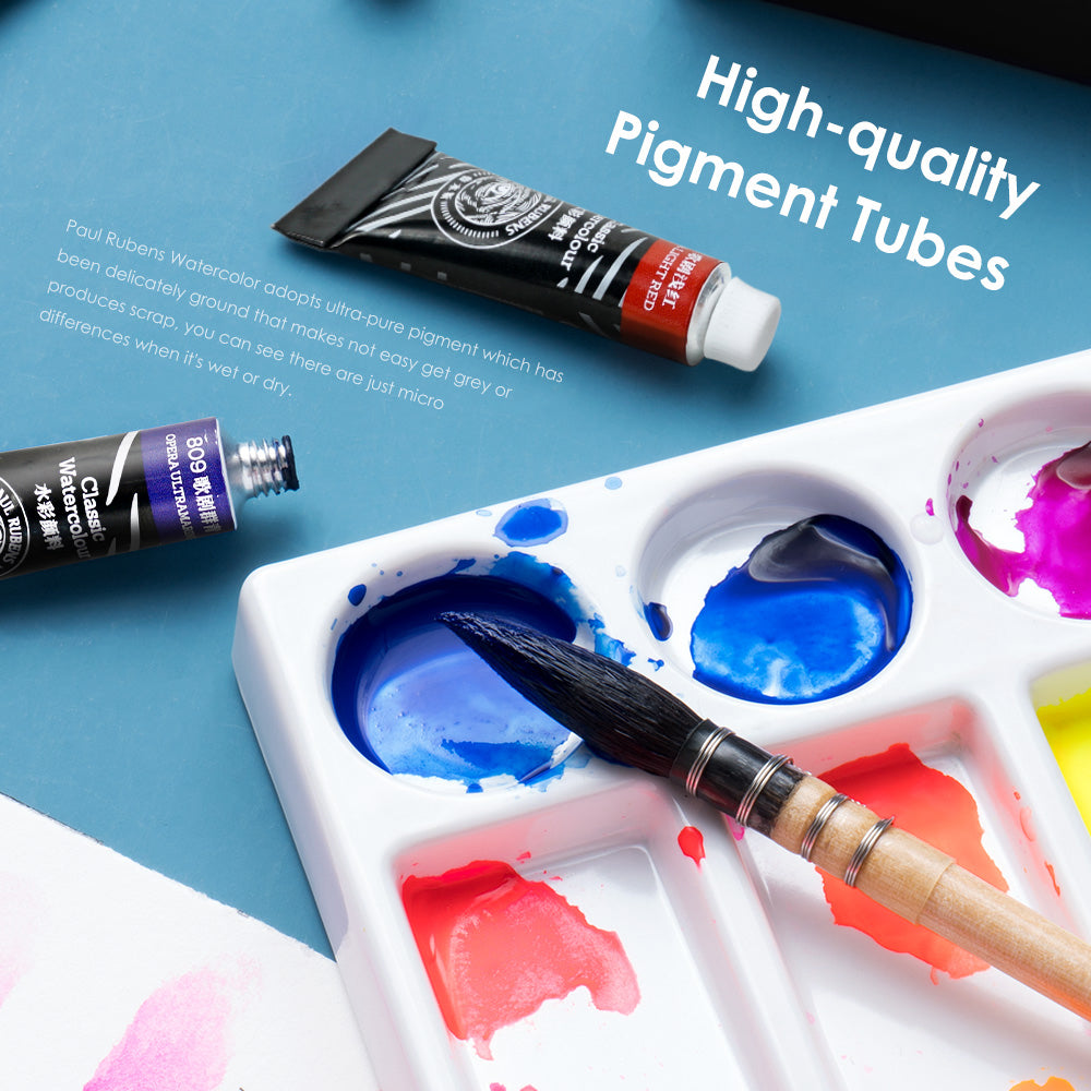 A paint brush and watercolor paint tubes on a table