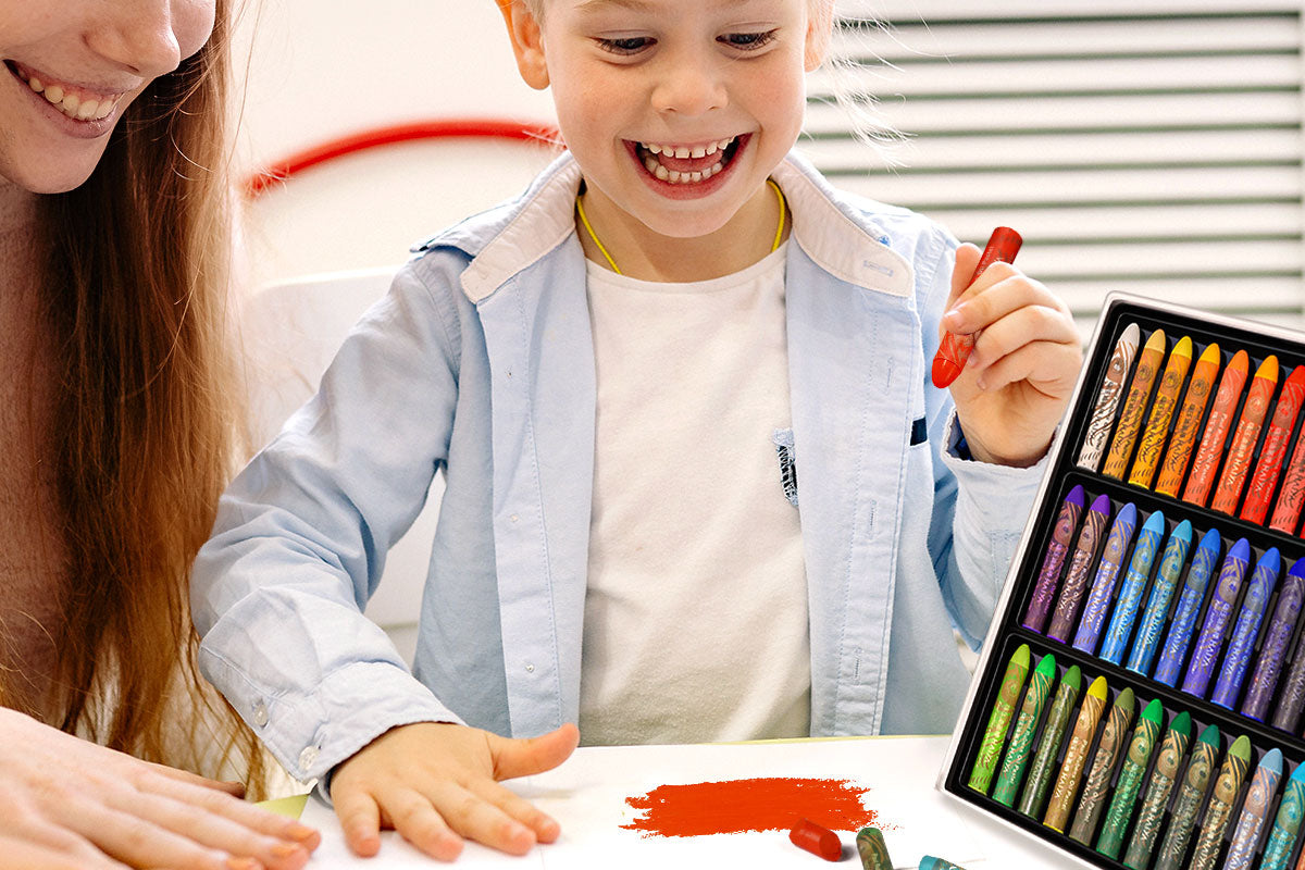 A little girl, accompanied by her mother, is happily drawing with a oil pastel